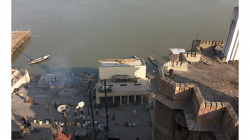 Varanasí - Pohled z balkonu hotelu Son Mony - u řeky stoupá dým z nebožtíka, stavba vpravo je moderní krematorium